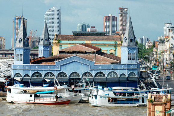 UIm porto com barcos atracados e uma construção azul no fundo