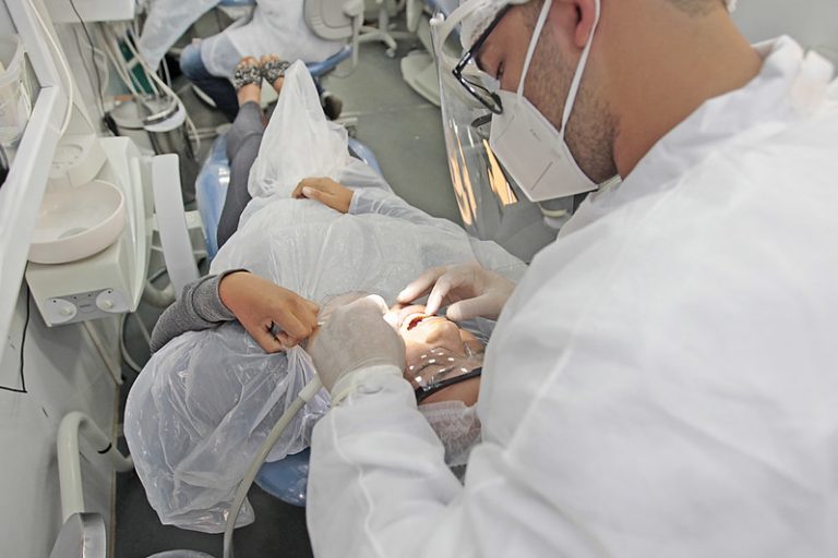 Dentista atendendo paciente em consultório
