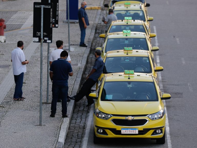 Fila de táxis parados ao longo do meio-fio