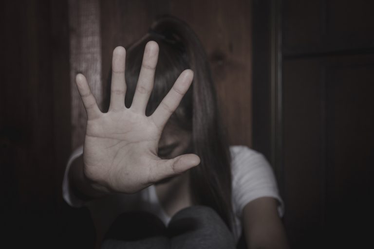 mulher se protege com a mão