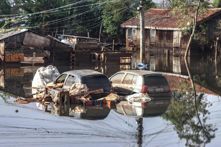 Bairro alagado com carros destruídos