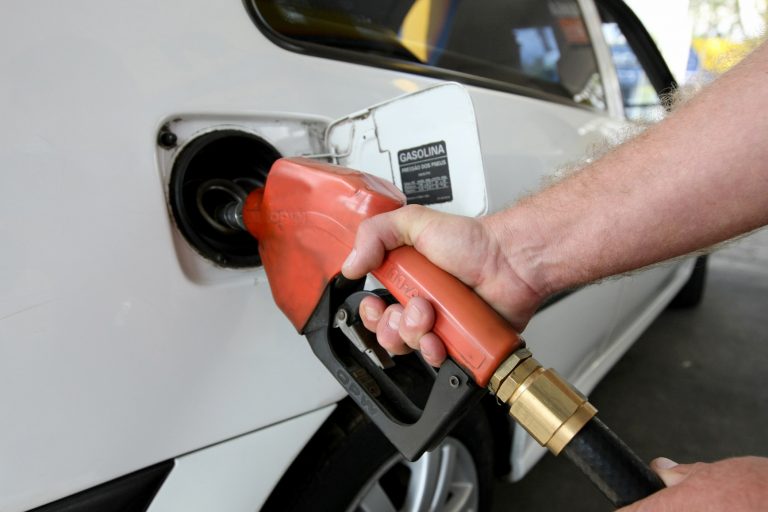 Frentista de gasolina abastece um carro