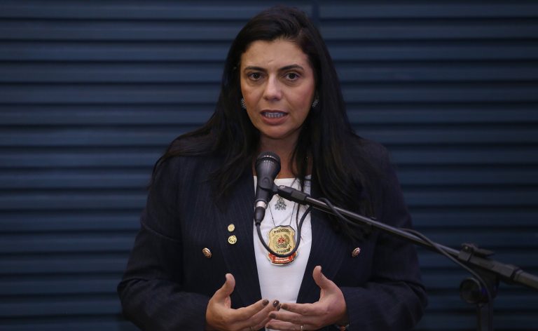 Deputada Delegada Ione está sentada à mesa