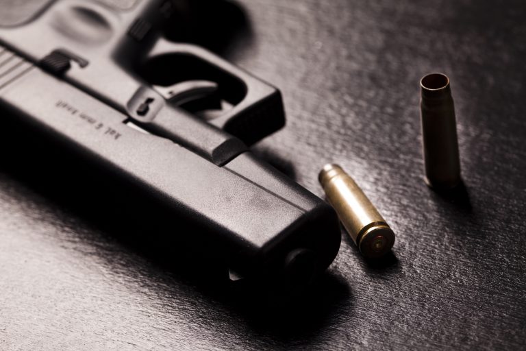 Revólver e balas em cima da mesa