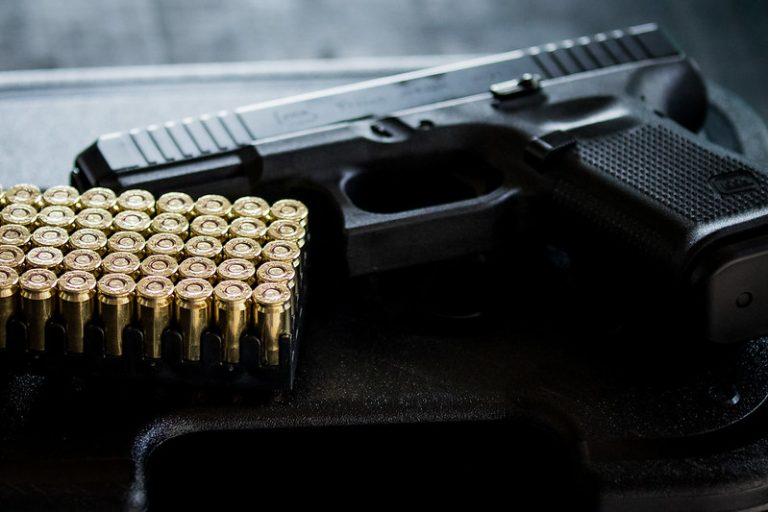 Revólver e balas em cima da mesa