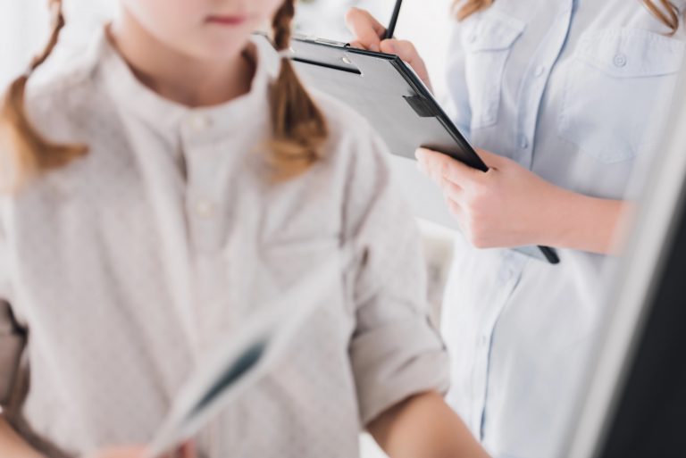 Criança é atendida por médico. A foto está cortada e não é possível ver os rostos