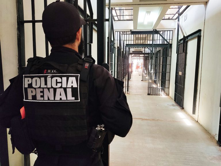 Policial no corredor de uma penitenciária