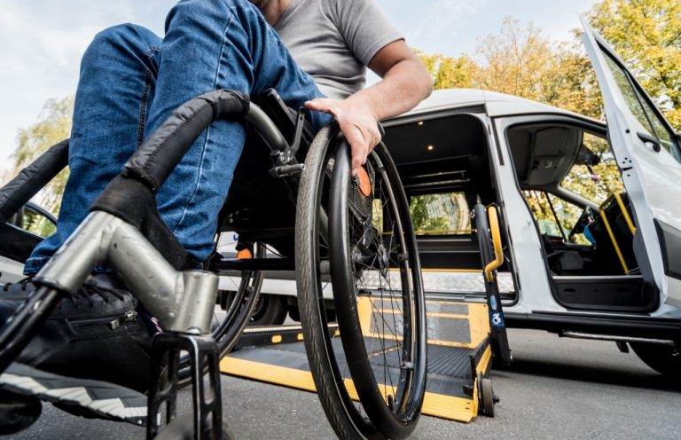 Pessoa com deficiência - Homem em cadeira de rodas entrando em carro adaptado