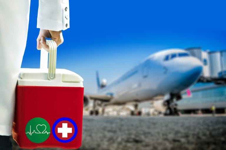Uma pessoa com jaleco branco segura uma caixa térmica. Ao fundo há um avião pousado
