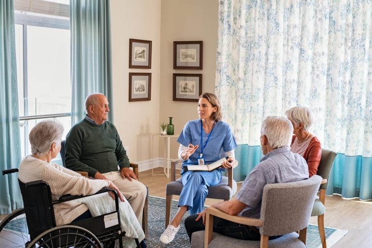 Enfermeira conversando com idosos durante terapia em grupo, idosos, asilo