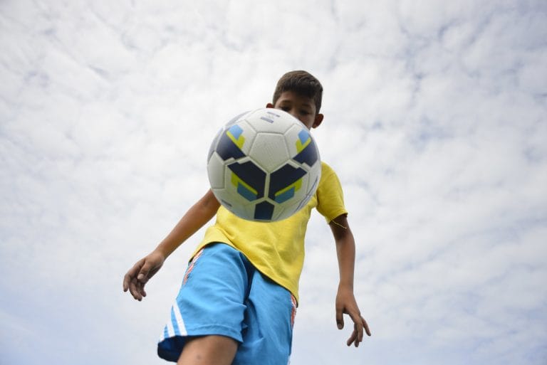 Esporte - futebol - lazer criança menino jogador bola infância atividade esportiva