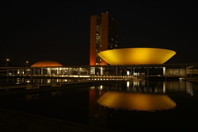 Prédio do Congresso iluminado de laranja