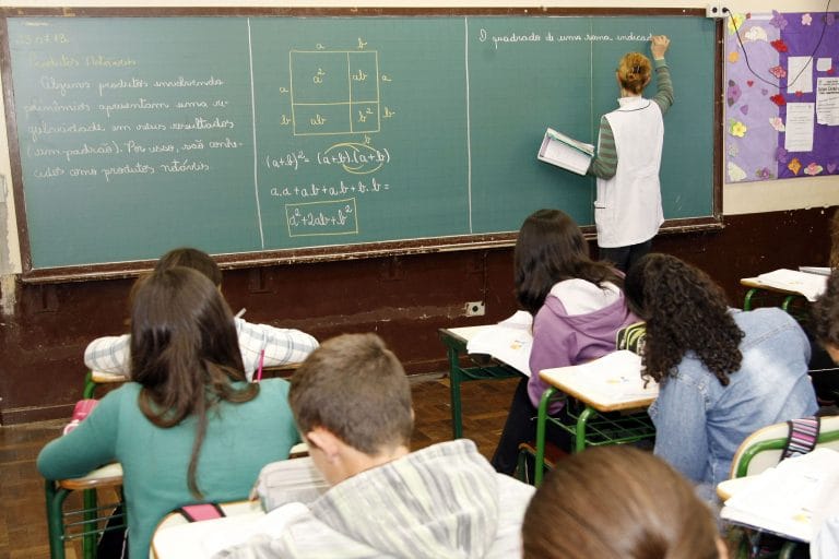 Professora escreve no quadro negro
