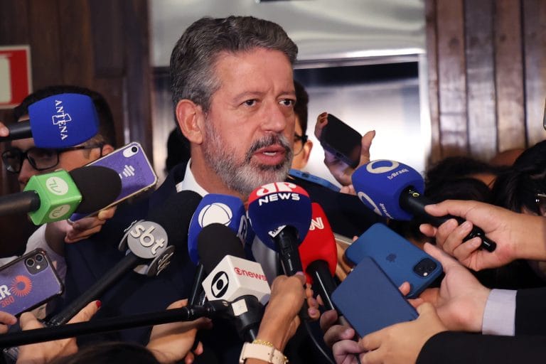 Arthur Lira está cercado de microfones