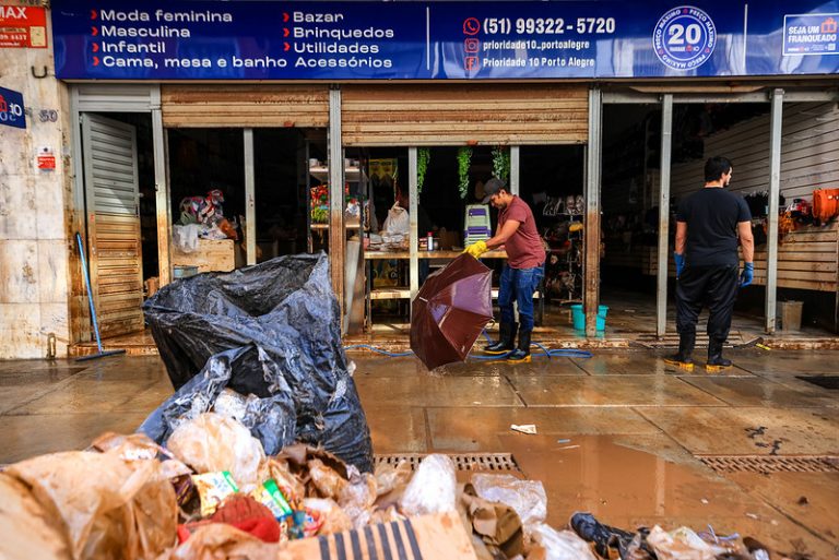 Comerciante limpa loja invadida pelas chuvas em Porto Alegre (RS)