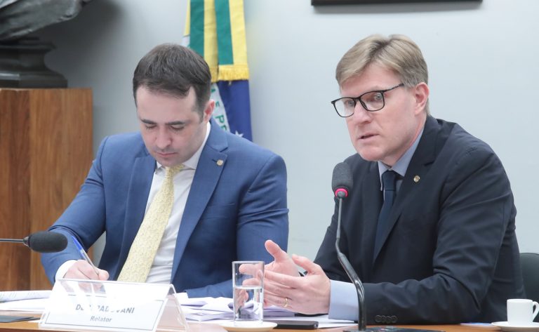 Dois homens estão sentados à mesa
