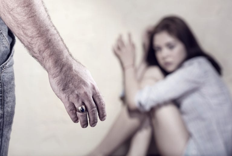 Homem ameça bater numa mulher que está encolhida num canto