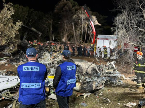 Investigadores olham restos de um avião que caiu
