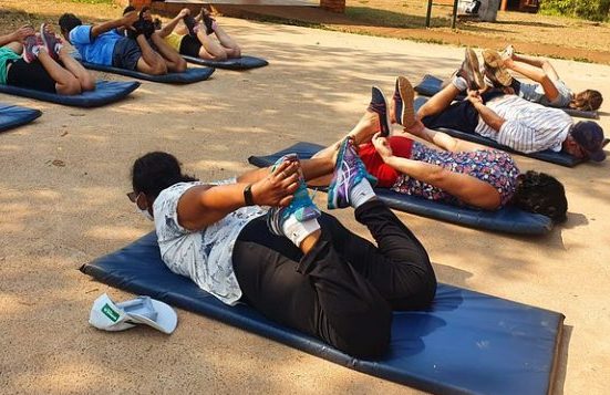 Pessoas deitadas em um colchonete fazendo atividade física
