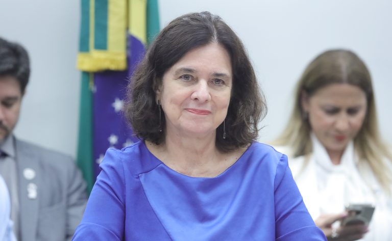 Ministra da Saúde, Nísia Trindade. Ela é uma mulher branca, com cabelo escuro na altura dos ombros. Ela veste uma blusa lilás