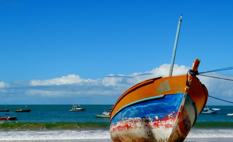Barco parado na areia num dia de sol