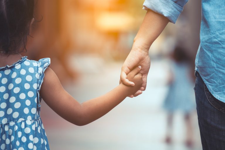 Mãe e filha segurando mão