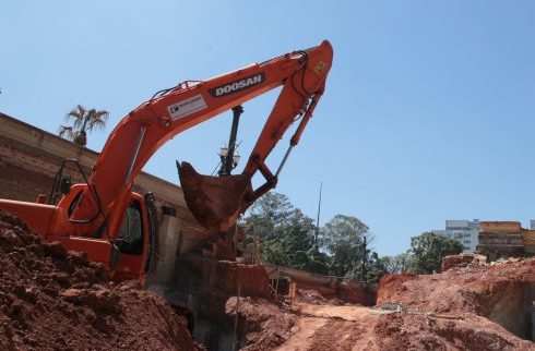 Uma escavadeira está parada no meio de uma obra