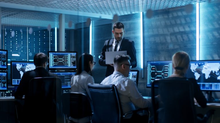 Pessoas trabalhando em seus computadores, analisando dados e trocando informações
